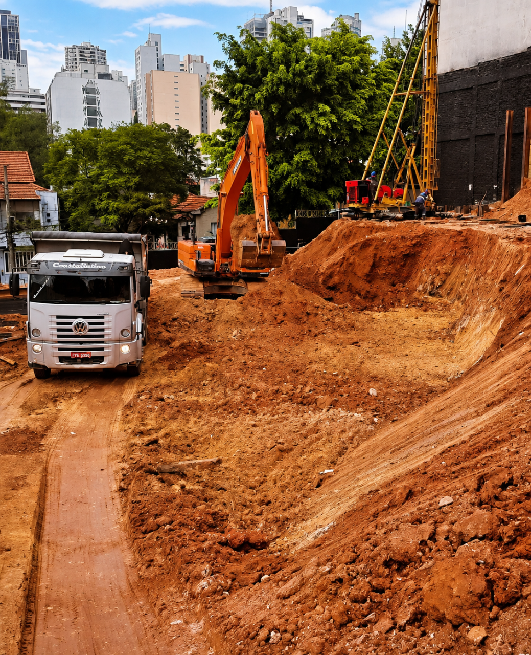 Escavadeira e caminhão em canteiro de obra